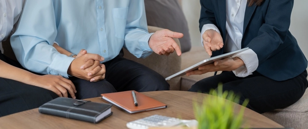 A snapshot of a family member supporting an individual while discussing alternatives to involuntary commitment with a specialist.