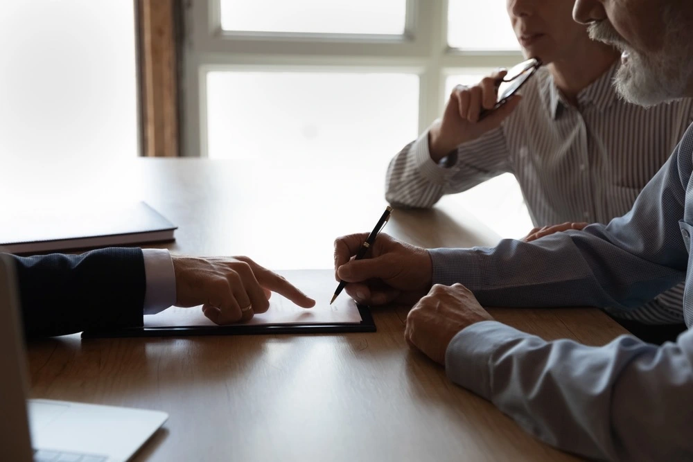 Family members sign documents with a lawyer, representing the various types of guardianships available in Florida.