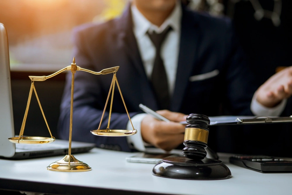 A lawyer in an office explains the Marchman Act, with legal documents and a gavel spread out on the desk.